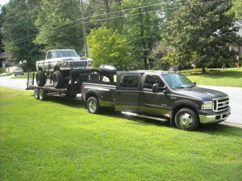 1979 Ford F-150 - A lifted 1979 Ford F-150 is transported on a trailer by a newer model Ford Super Duty truck.