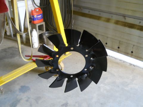 1992 Ford Bronco - A black fan blade is suspended from yellow equipment in a workshop setting.