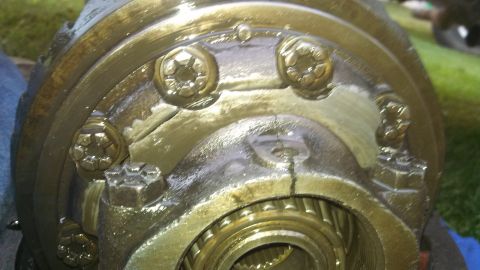 1979 Ford Bronco - This is a close-up view of a greasy differential housing, showing several bolts and internal gears.