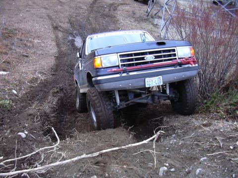 1991 Ford Bronco - This 1991 Ford Bronco is navigating a challenging muddy terrain, demonstrating its off-road capabilities.