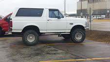 1994 Ford Bronco - A white Ford Bronco is parked outside on a cloudy day.