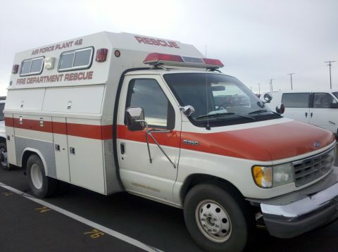1989 Ford Bronco - This rescue vehicle, marked "AIR FORCE PLANT 42 FIRE DEPARTMENT RESCUE", is parked outdoors next to another white van.