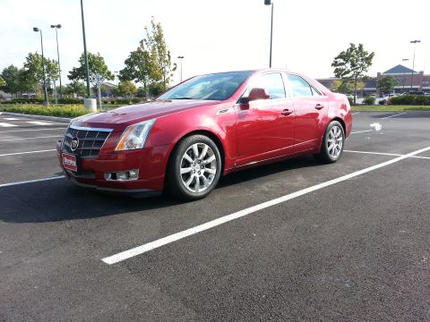2008 Cadillac CTS - A red Cadillac CTS is parked in a parking lot, showing its front three-quarter view.