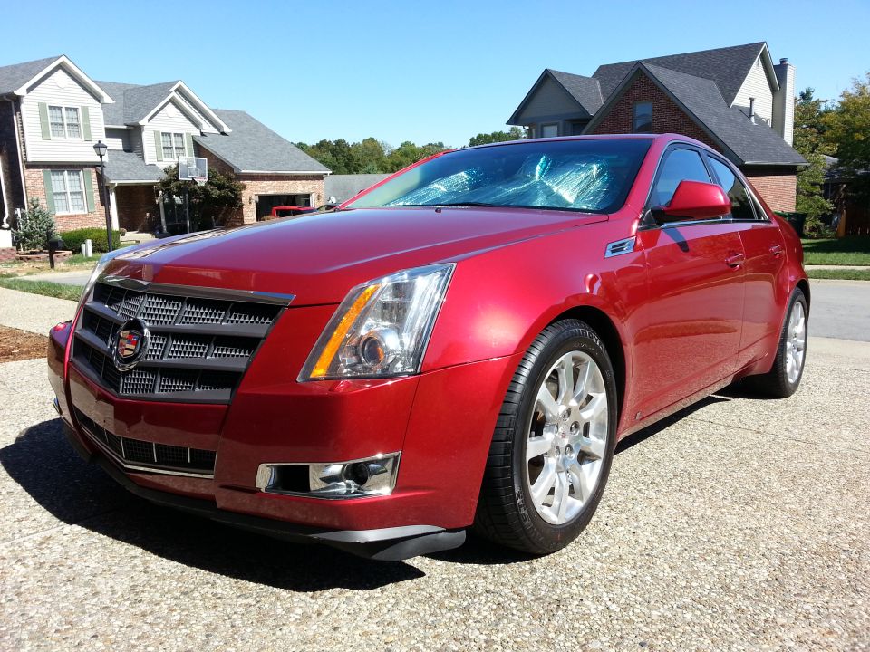 Red 2008 Cadillac CTS sedan parked on driveway, front 3/4 view