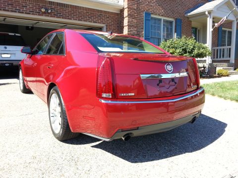 2008 Cadillac CTS - Rear view of a red 2008 Cadillac CTS parked outside a brick house.