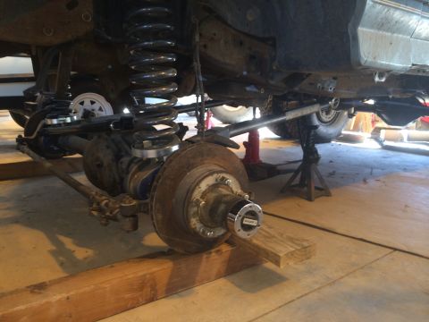 1996 Ford Bronco - The underside of a vehicle is shown with its front axle and suspension system exposed for maintenance.