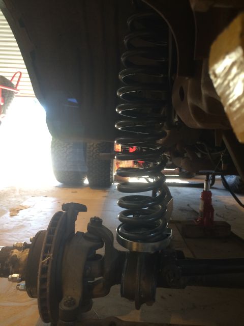 1996 Ford Bronco - This image shows a close-up view of a vehicle's suspension system, focusing on the coil spring and associated parts.