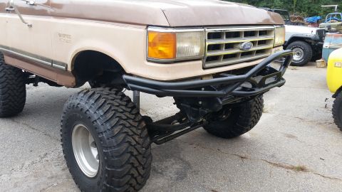 1988 Ford Bronco - This lifted Ford Bronco features a custom front bumper and large off-road tires.