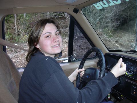 1991 Ford Bronco - A woman smiles from the driver's seat of a Ford Bronco, with the dashboard and steering wheel in view.