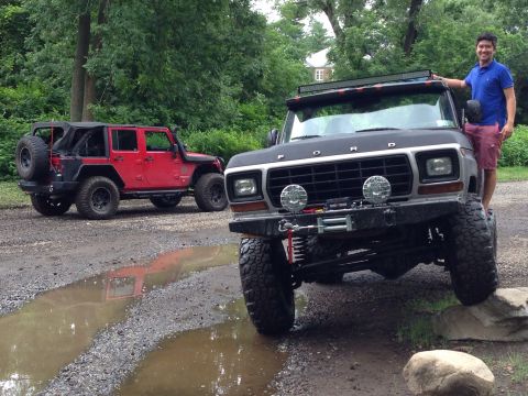 1979 Ford Bronco - A man stands next to a modified 1979 Ford Bronco, with a red Jeep in the background.