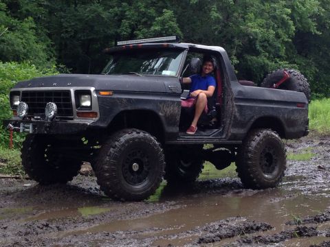 1979 Ford Bronco - This lifted Ford Bronco is equipped for off-road adventures, seen here navigating a muddy trail.
