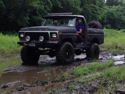 1979 Ford Bronco - This modified 1978 Ford Bronco navigates a muddy trail with its doors removed and a spare tire mounted in the rear.