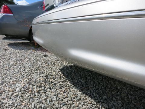 1991 Ford LTD Crown Victoria - Close-up of a silver car's rear side, with another vehicle visible behind it.