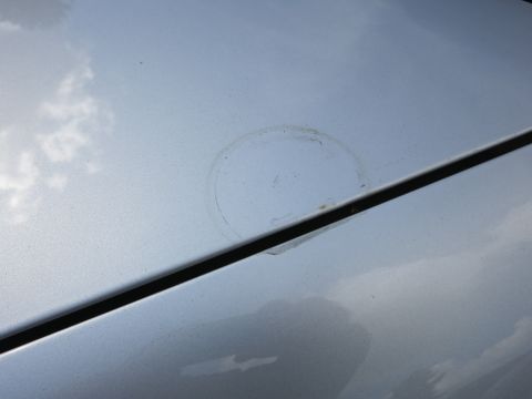 1991 Ford LTD Crown Victoria - Close-up of a silver car hood showing a circular stain and a visible seam line.
