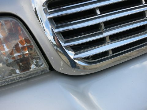 1991 Ford LTD Crown Victoria - Detail of a vehicle's front end, showing the grille and headlight.