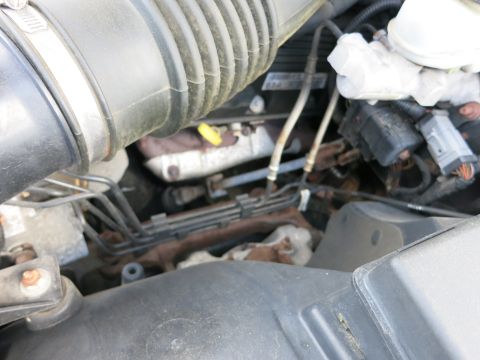 1991 Ford LTD Crown Victoria - Close-up view of engine components, including hoses and wiring harnesses, in a vehicle's engine bay.