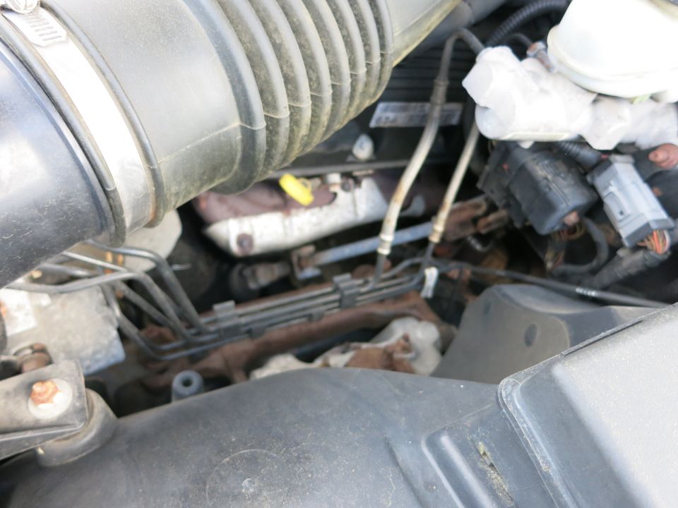 Engine bay with air intake tube, exhaust manifold, and electrical connectors visible
