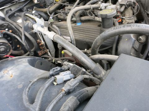 1991 Ford LTD Crown Victoria - Close-up view of a vehicle's engine compartment, showing various hoses and electrical connections.