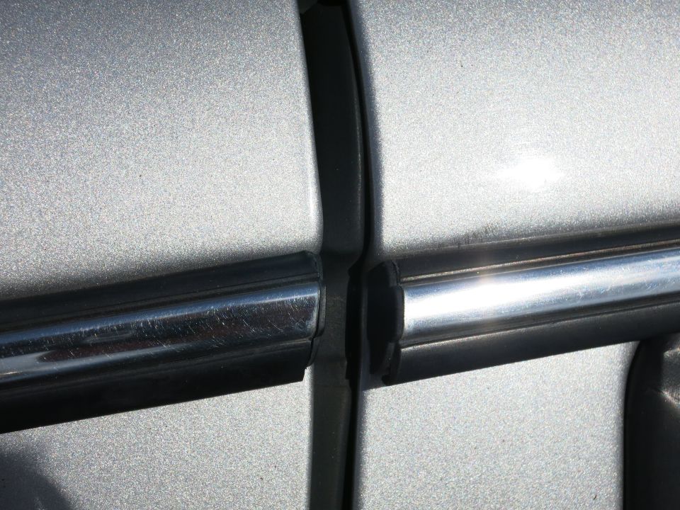 close up of silver car door trim and body panel gap