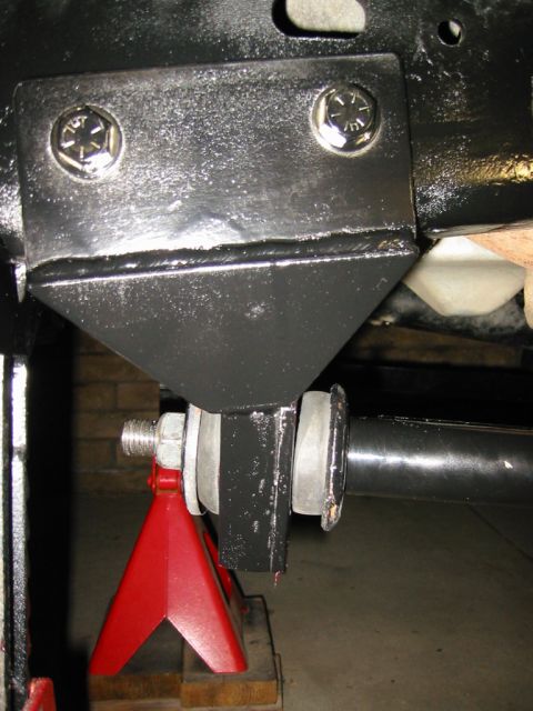 1985 Ford Bronco - Close-up of a vehicle's suspension system, supported by a red jack stand.