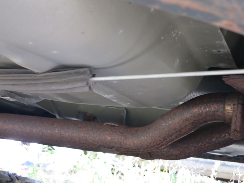 Underbody view of a vehicle showing the exhaust pipe and fuel line