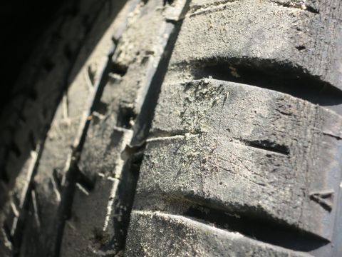 1991 Ford LTD Crown Victoria - A close-up view of a dusty tire tread shows significant wear.