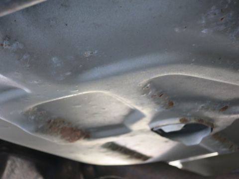 1991 Ford LTD Crown Victoria - The underside of a vehicle shows some surface rust and a plastic cover or component.