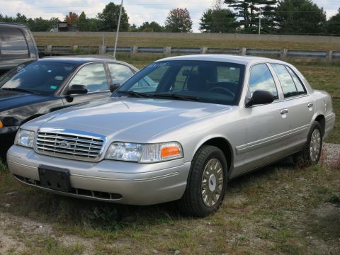 1991 Ford LTD Crown Victoria - Silver sedan parked outdoors with a black vehicle to its left.