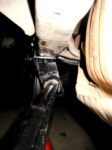 1985 Ford Bronco - Vehicle frame is supported by a jack stand, indicating maintenance or repair work.
