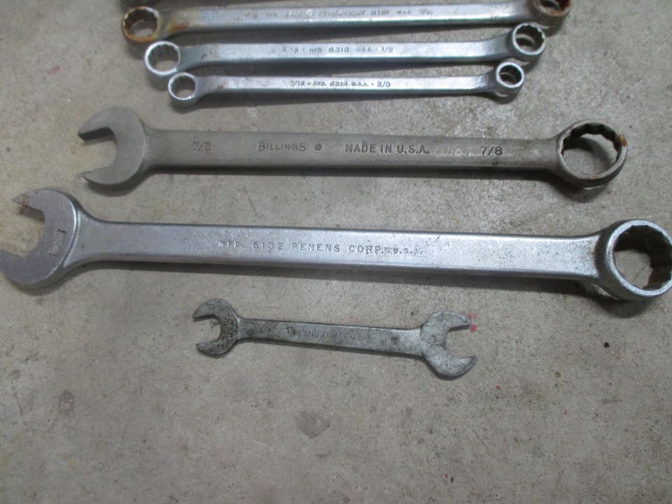 Several wrenches on a concrete surface, including a BILLINGS 7/8 wrench and a PENENS CORP wrench