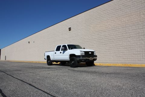 2006 Chevrolet Silverado 2500 - White 2006 Chevrolet Silverado 2500 pickup truck parked outside a building.