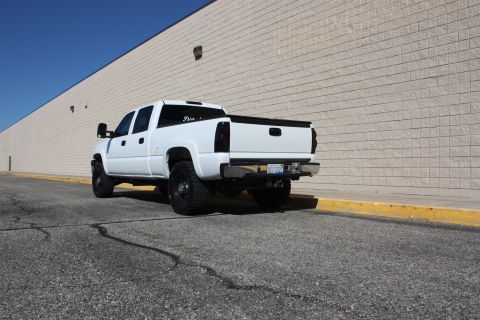2006 Chevrolet Silverado 2500 - Rear view of a white pickup truck with a lifted suspension and tinted windows.