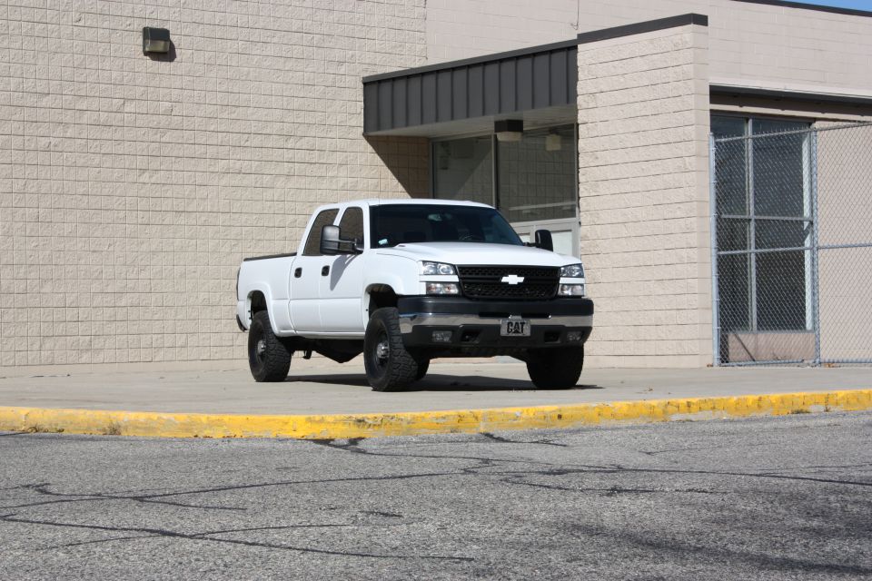 White pickup truck parked outside a building. License plate says CAT