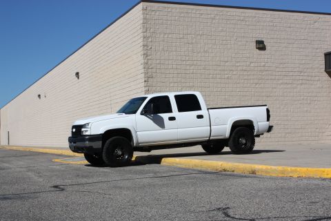 2006 Chevrolet Silverado 2500 - White 2006 Chevrolet Silverado 2500 pickup truck parked on asphalt with a yellow curb.