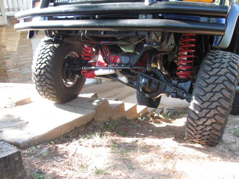 1982 Ford Bronco - Undercarriage view of an off-road vehicle, highlighting its suspension system with prominent red shocks and springs.
