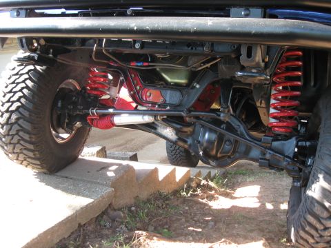 1982 Ford Bronco - Undercarriage view of a modified off-road vehicle's front suspension and drivetrain components.