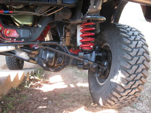 1982 Ford Bronco - The heavy-duty suspension components and large off-road tire are visible in this underside shot.