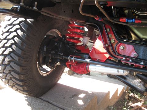 1982 Ford Bronco - Close-up view of the suspension and drivetrain components of a heavily modified off-road vehicle.