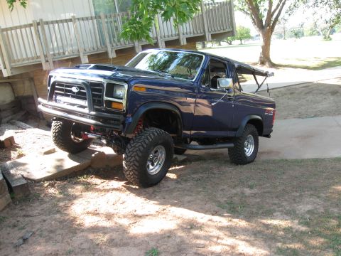 1982 Ford Bronco - This lifted 1980 Ford Bronco is shown in a 3/4 front view, parked outdoors near a wooden structure.