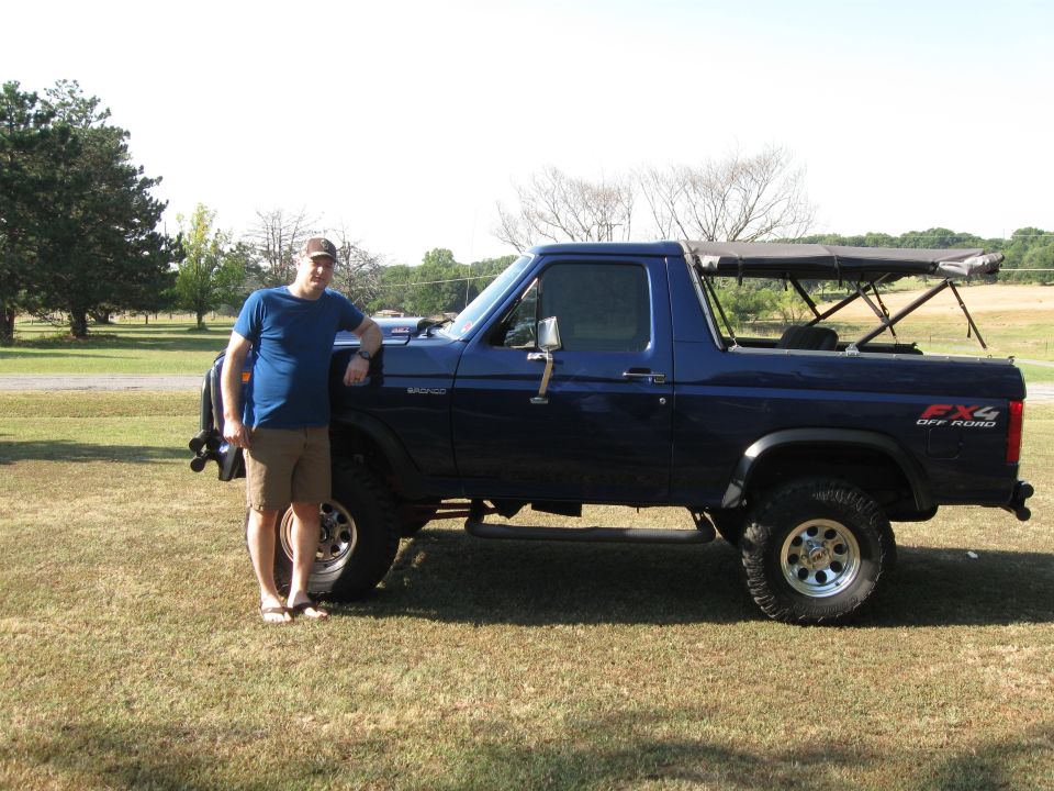 Blue 1982 Ford Bronco side view with a man standing beside it