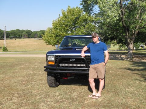 1982 Ford Bronco - Man poses with his modified blue Ford truck, likely from the early 1980s.