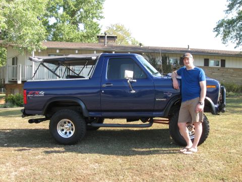 1982 Ford Bronco - A man poses with a lifted blue 1982 Ford Bronco in a grassy yard.