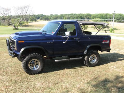 1982 Ford Bronco - This blue 1982 Ford Bronco features a removable soft top and aggressive off-road tires, ready for adventure.