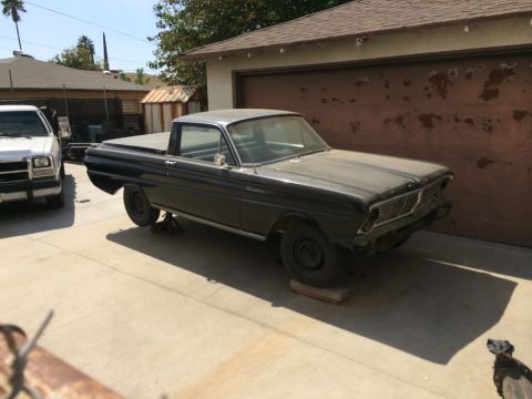 1968 Ford Mustang - A dusty black Ford Falcon Ranchero pickup truck is parked in a driveway, supported by jack stands.