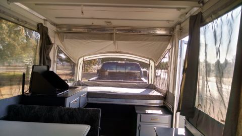 1985 Jeep CJ7 - Pop-up camper interior with a pickup truck seen through the rear window.