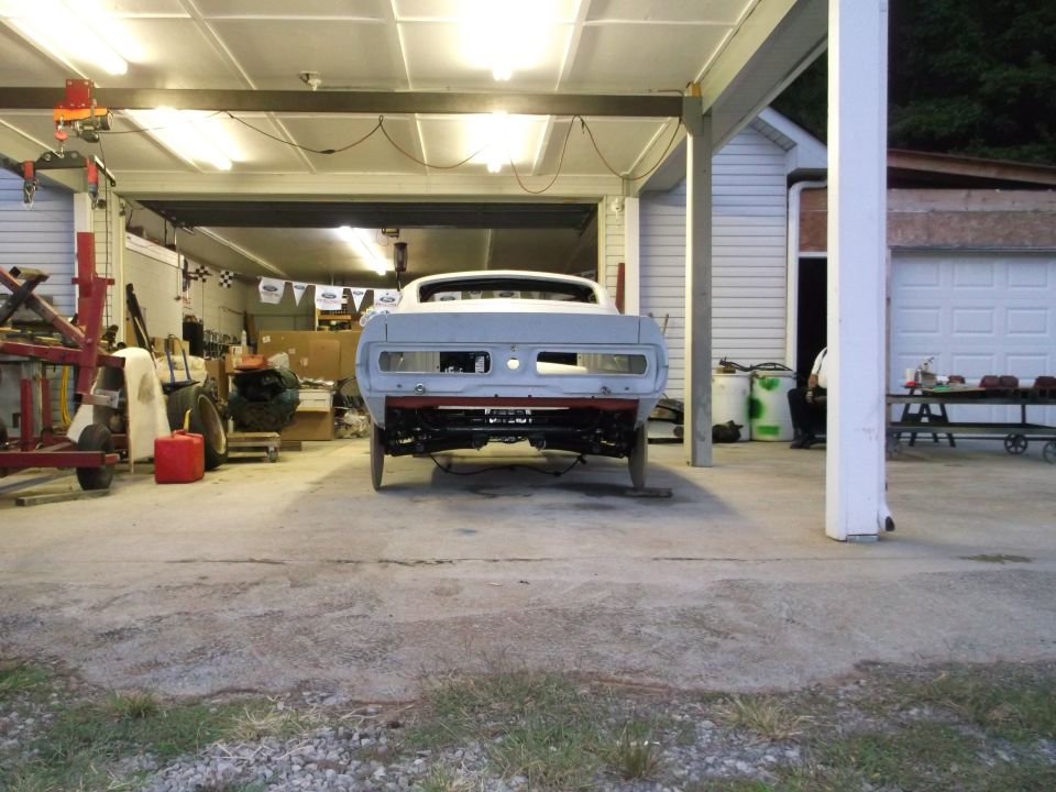 1967 Ford Mustang rear view, undergoing restoration in a garage