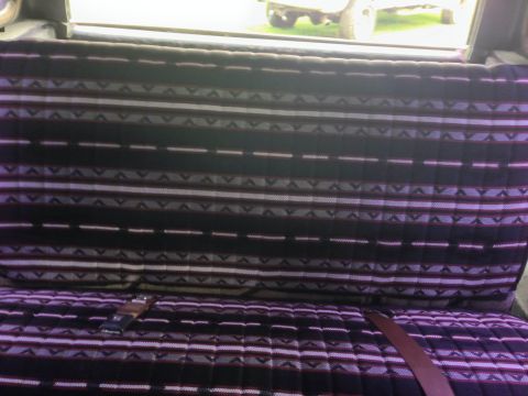 1979 Ford Bronco - Patterned seats visible inside a vehicle, with a seatbelt fastened.