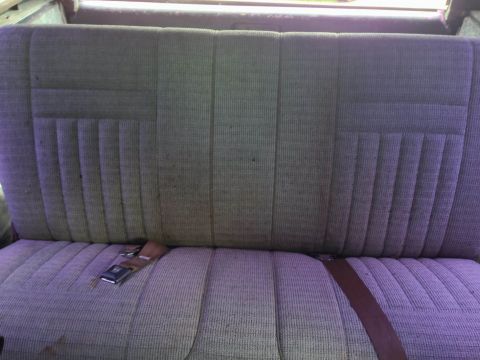 1979 Ford Bronco - The interior rear seat features a patterned fabric with a seatbelt visible on the cushion.