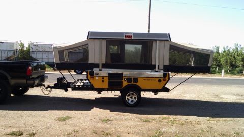 1985 Jeep CJ7 - Pop-up camper trailer towed by a black truck.
