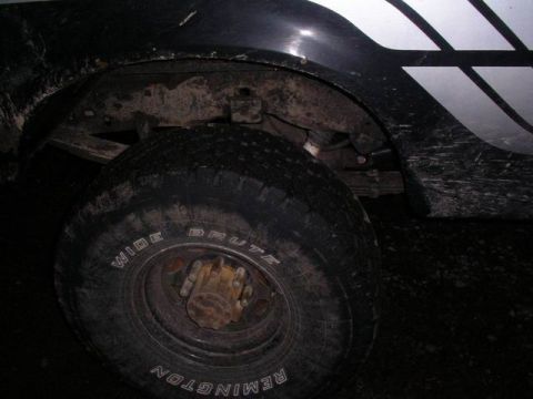 1990 Ford F-150 - Close-up of a muddy 1990 Ford F-150 truck wheel and fender with white graphics.